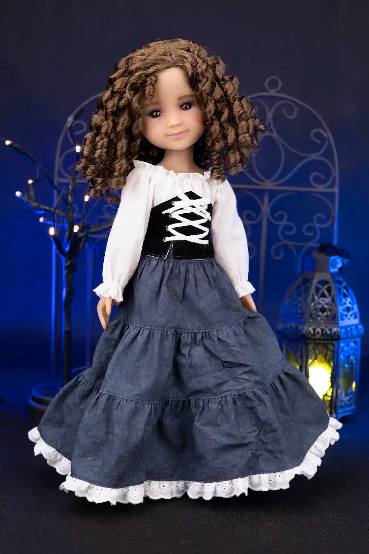 Clark wearing a dark blue dress with white lace trim against a dark background