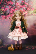 Eden in a floral dress with a green cardigan against a cherry blossom background