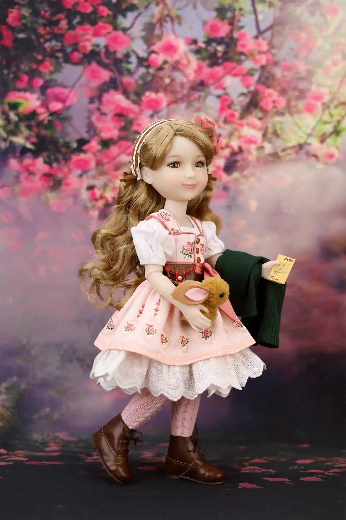 Eden in traditional outfit with floral dress and brown boots against a cherry blossom background