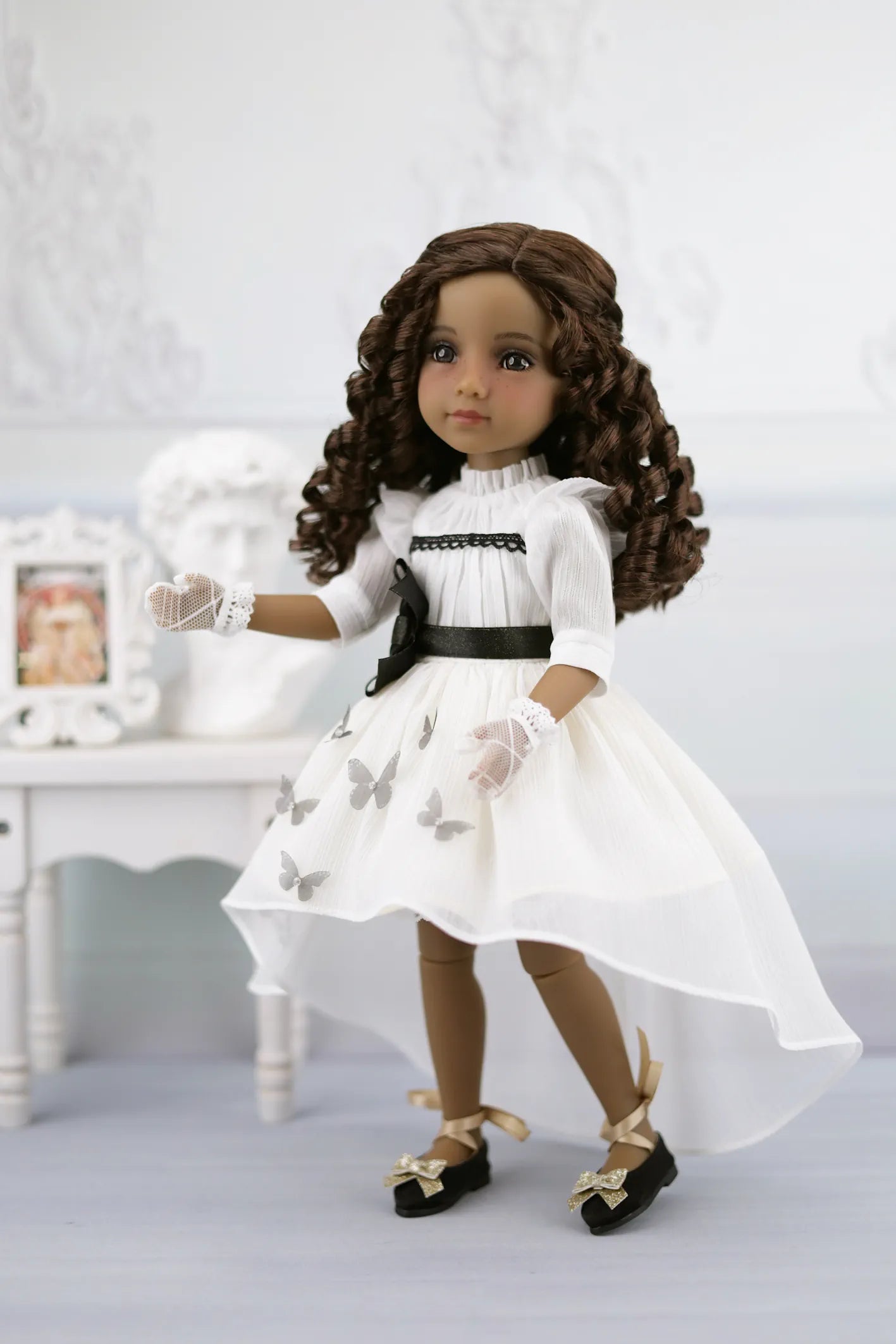 Esther in a white dress with black butterfly patterns on a white background