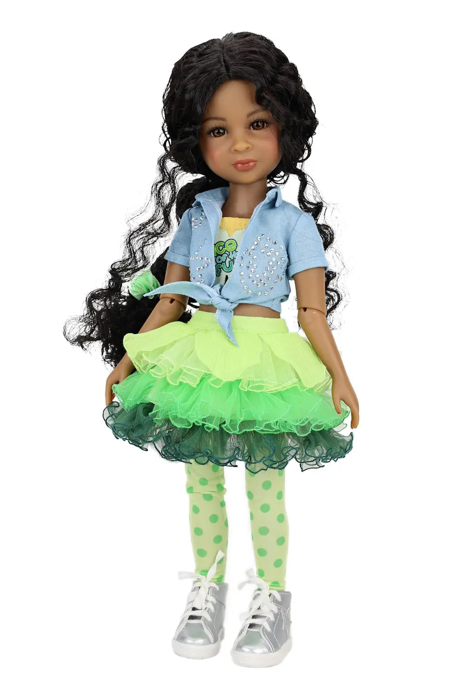 Jada wearing a green and black outfit with a blue jacket on a white background