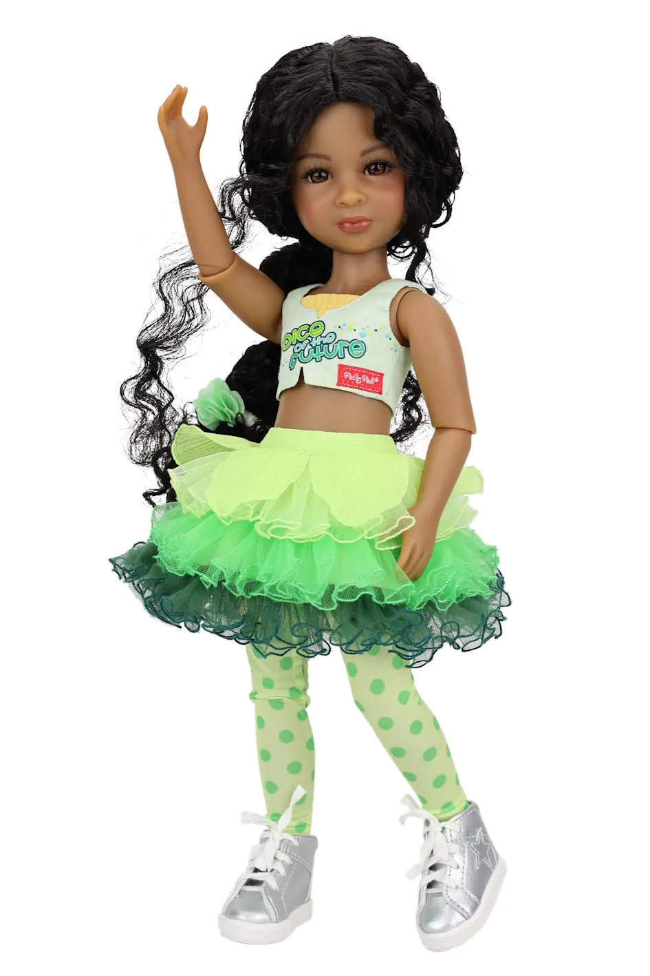 Jada wearing a green outfit with a skirt and polka dot leggings on a white background