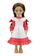 Jeannette, a doll with braided brown hair and red bows, wears a red checkered dress with a white apron, a cross necklace, and brown shoes.