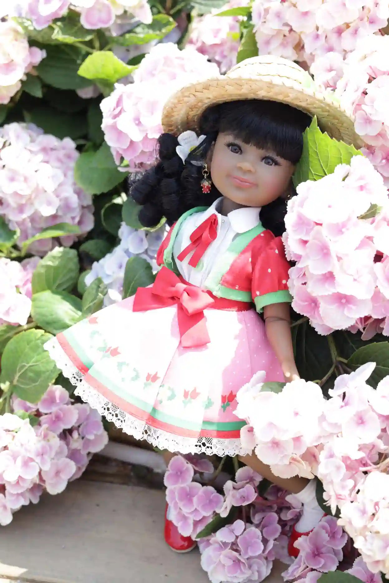 Kyra in a traditional outfit surrounded by pink flowers