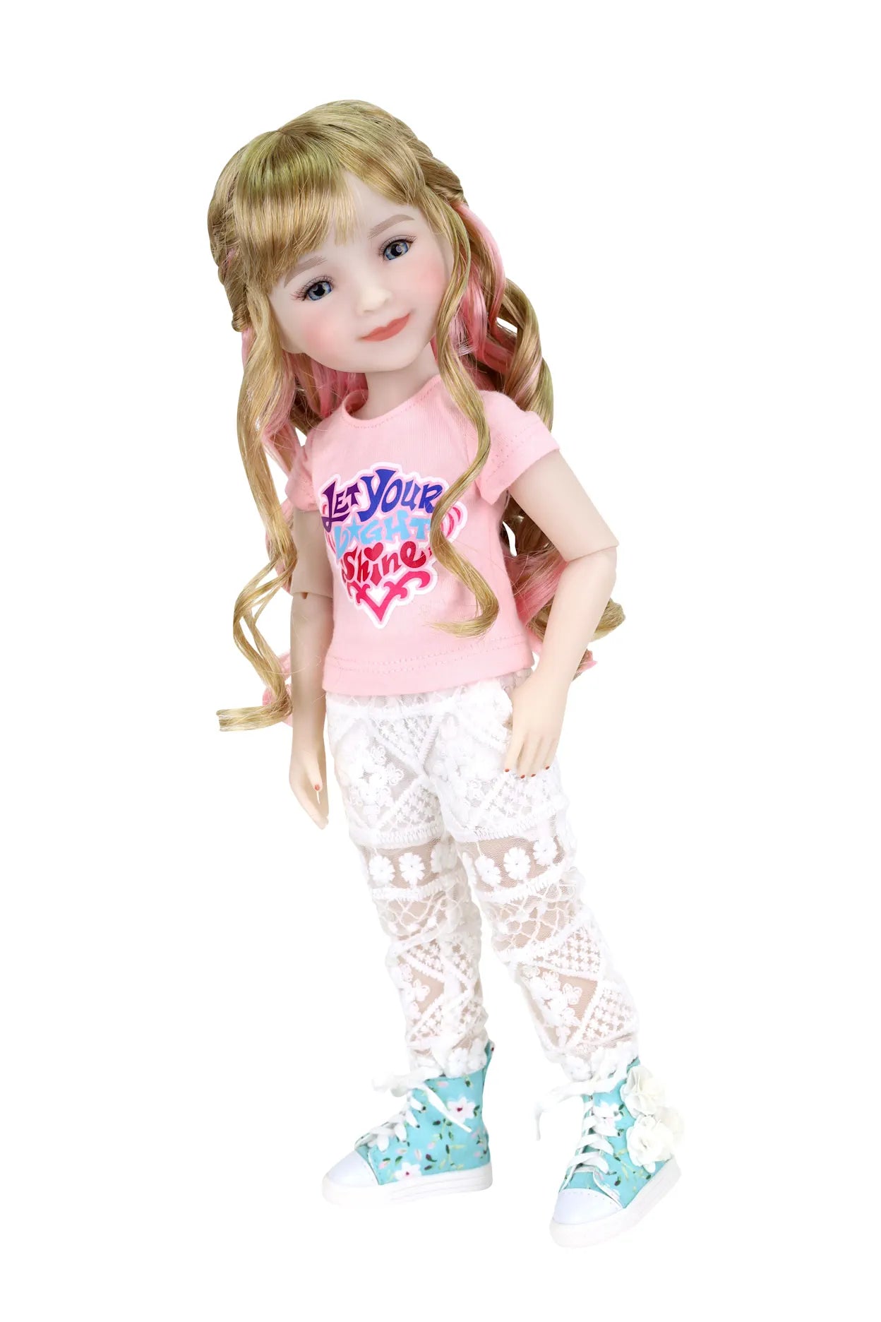 Sara, blonde hair with pink highlights, in pink T-shirt, lace leggings, blue sneakers, hand in pocket, white background.