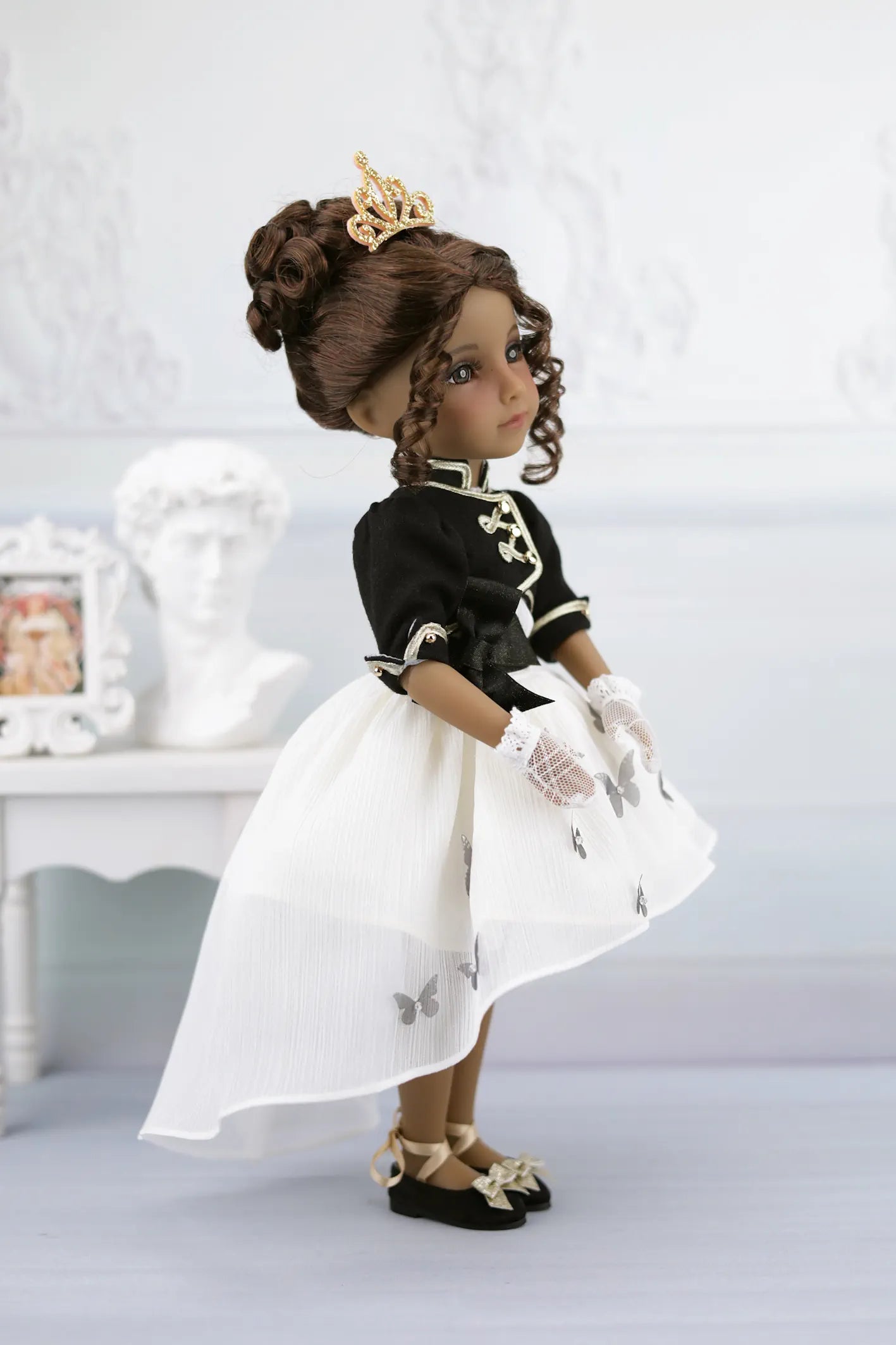Esther in a black and white outfit with a crown on a white background