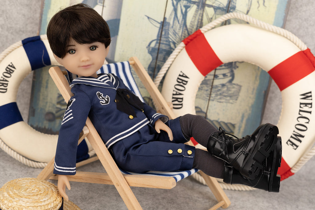 Tyler in a nautical outfit sitting on a chair with lifebuoys in the background