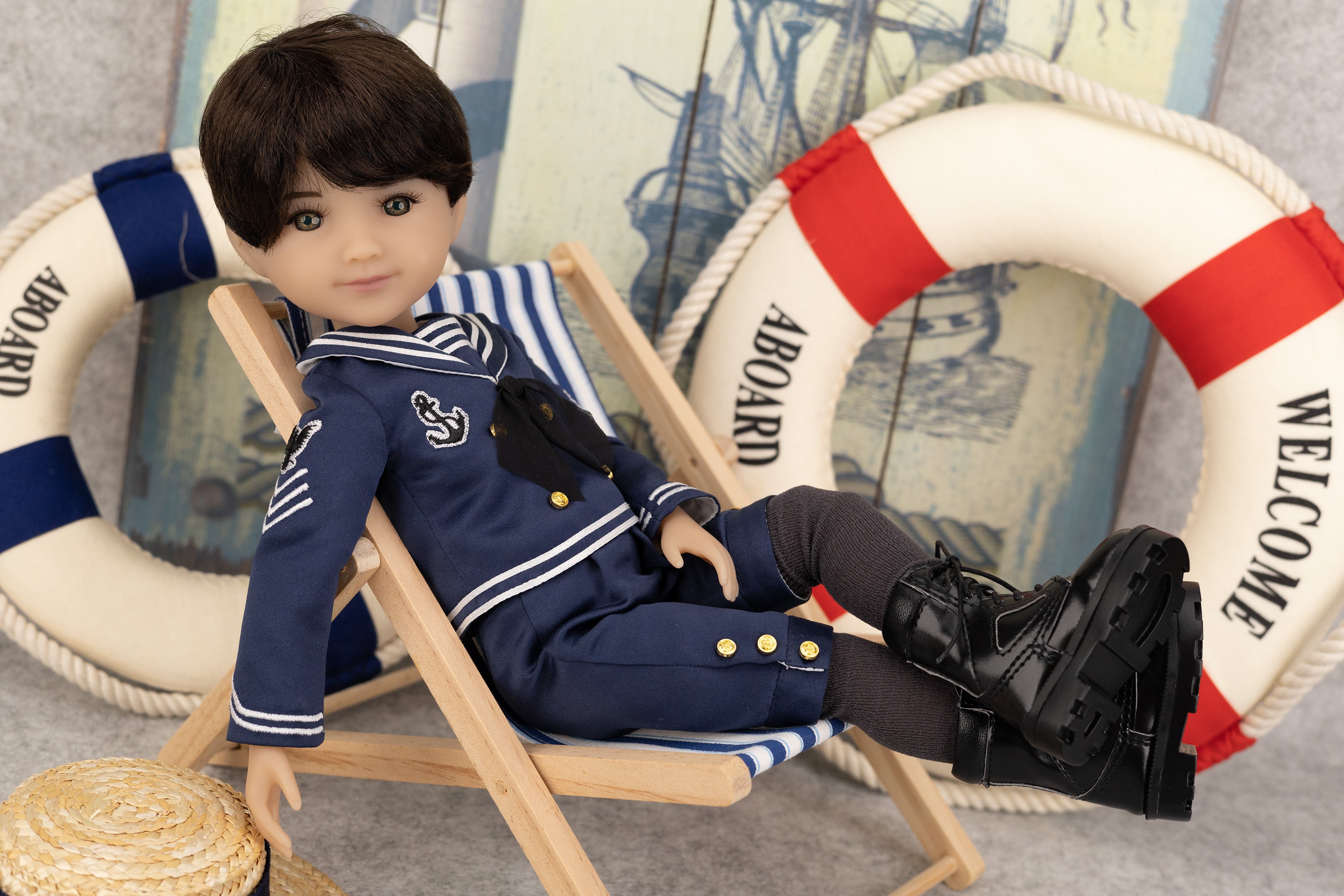 Tyler in a nautical outfit sitting on a chair with lifebuoys in the background