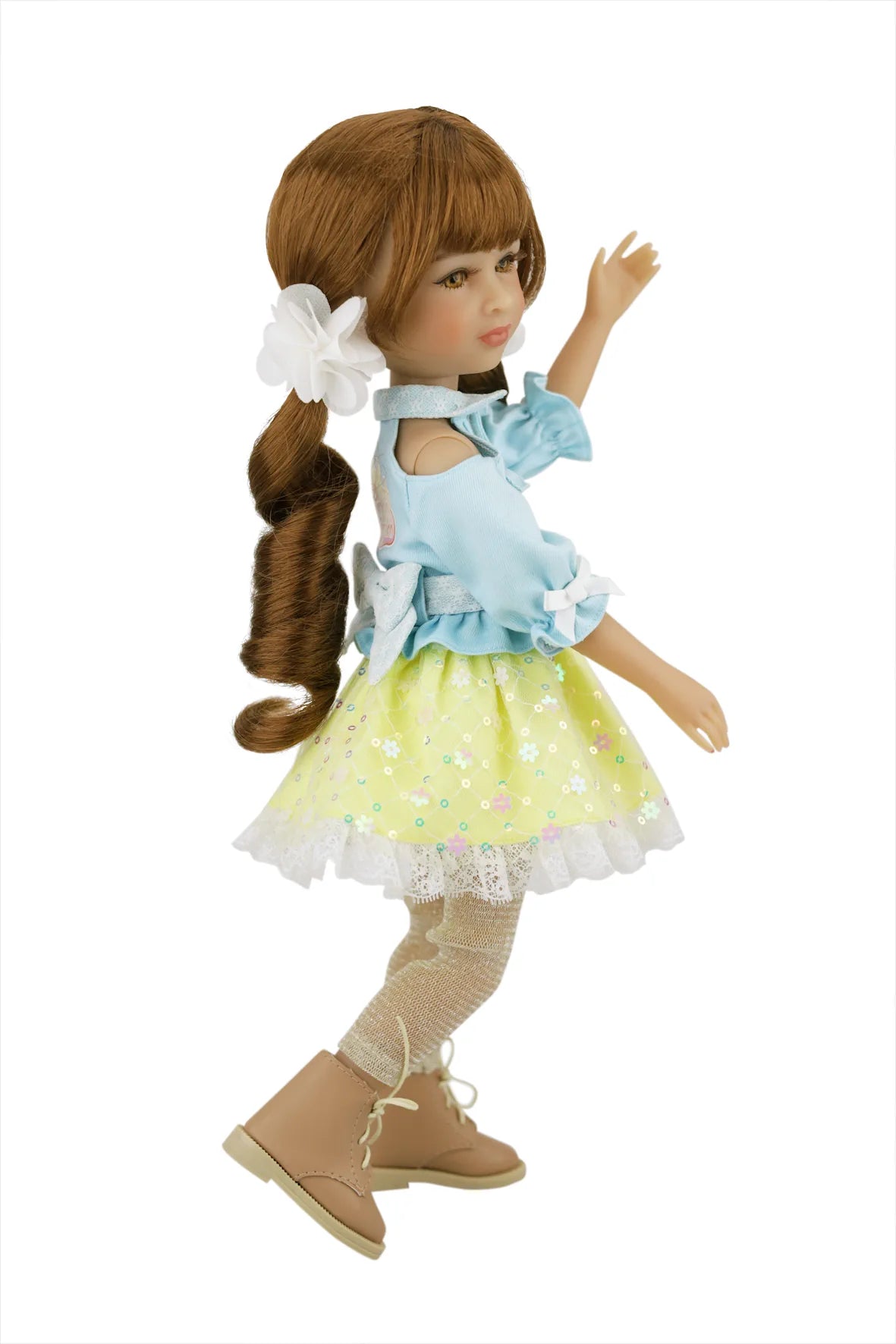 Valeria with long brown hair wearing a light blue top and yellow polka dot skirt on a white background