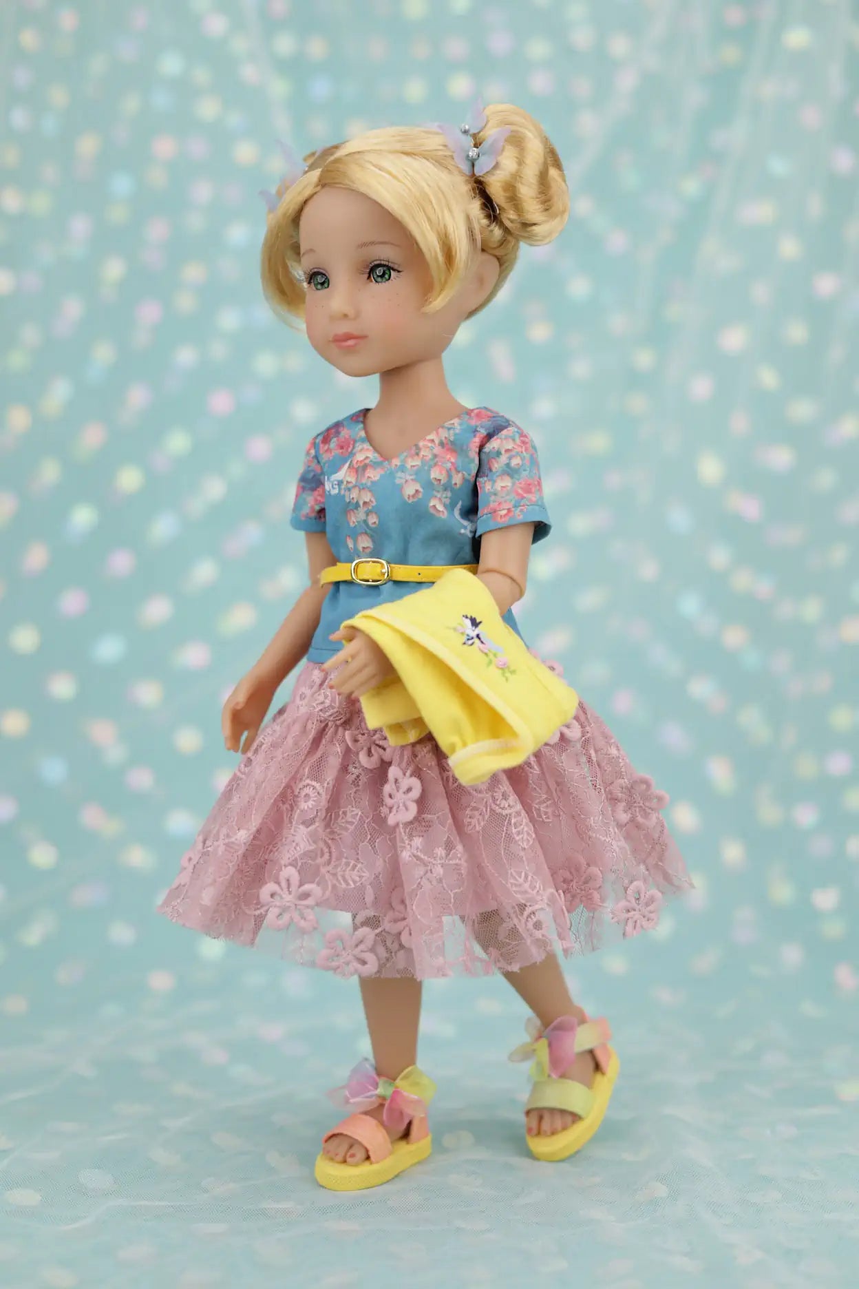 Juniper wearing a floral dress with a yellow apron against a polka dot background