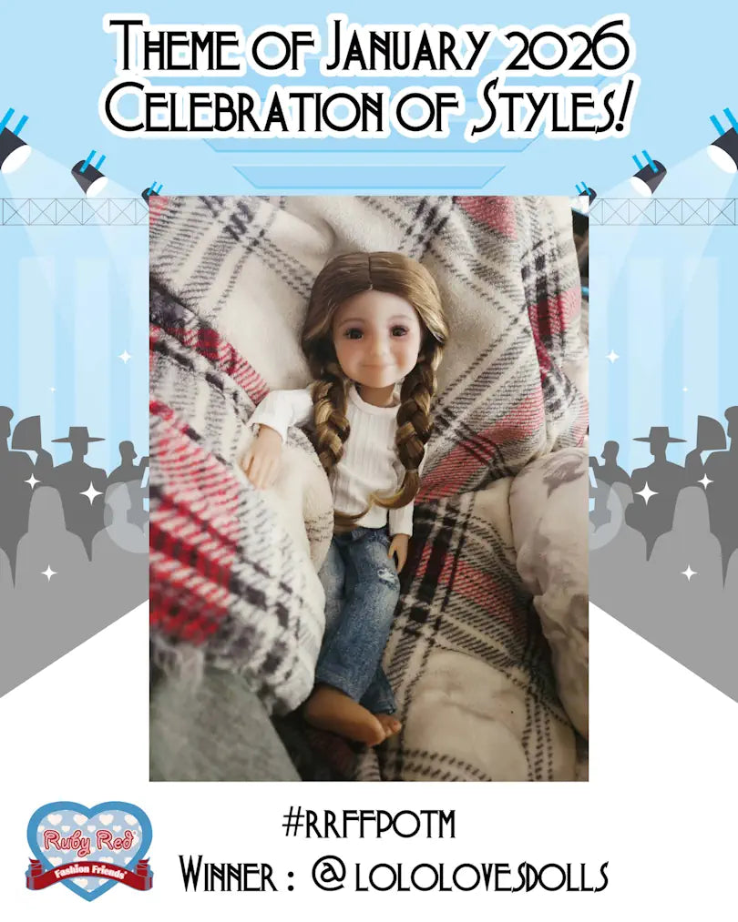 Doll wrapped in a plaid blanket with text about January 2026 theme and Ruby Red winner.
