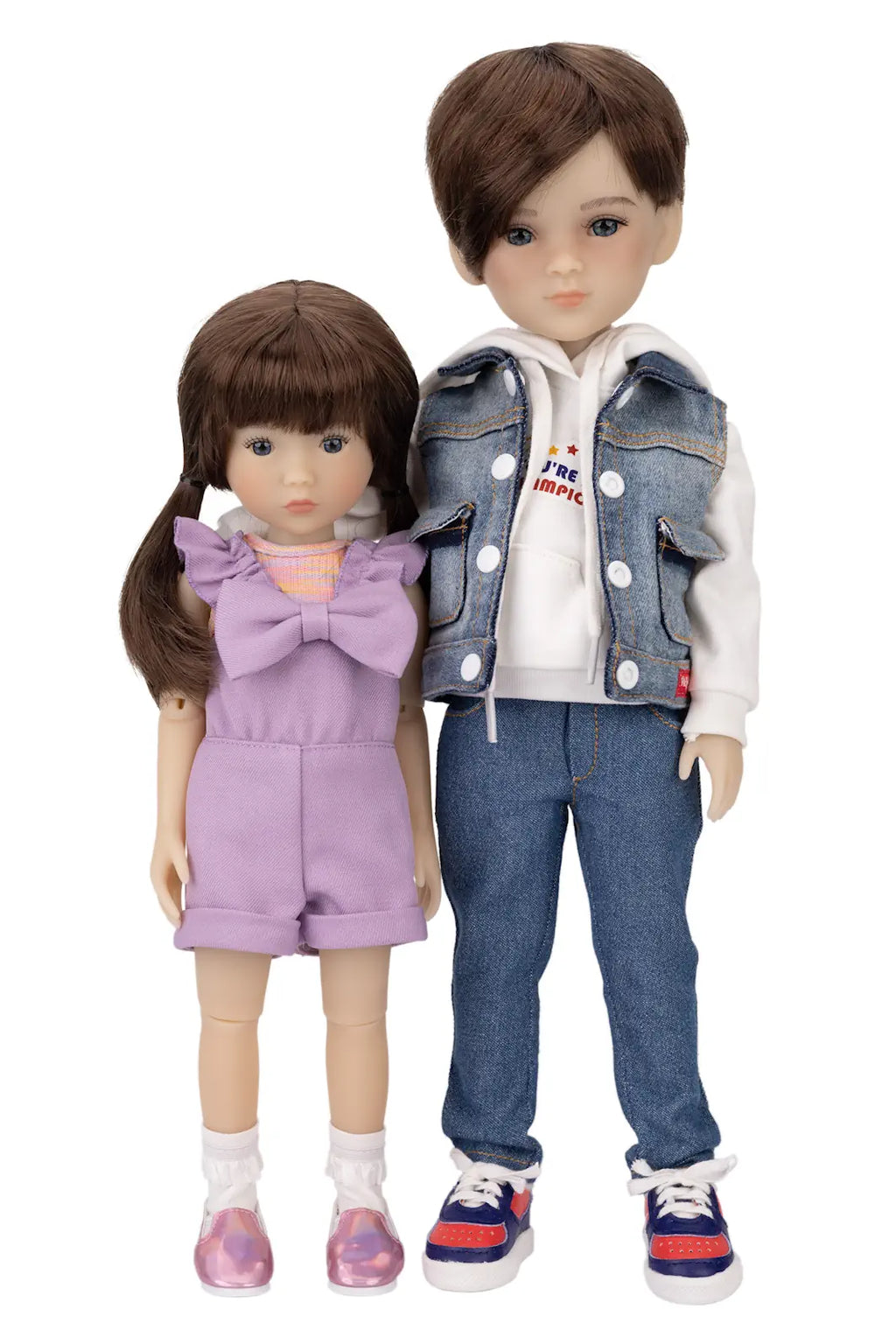 Two dolls, one girl and one boy, wearing outfits with a denim jacket and purple dress.