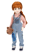 Doll wearing a pink shirt and blue overalls with a brown teddy bear, on a white background