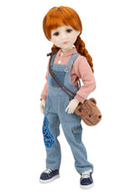 Doll with red hair in pigtails, wearing a pink shirt and blue denim overalls, holding a brown teddy bear.