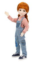 Doll wearing a pink shirt and blue overalls on a white background
