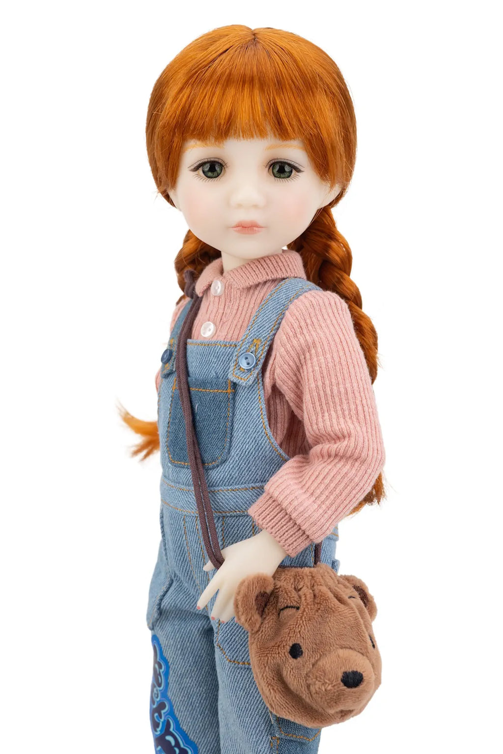 Tina doll with red hair styled in pigtails, wearing a pink sweater and blue overalls, holding a brown bag with a bear design.
