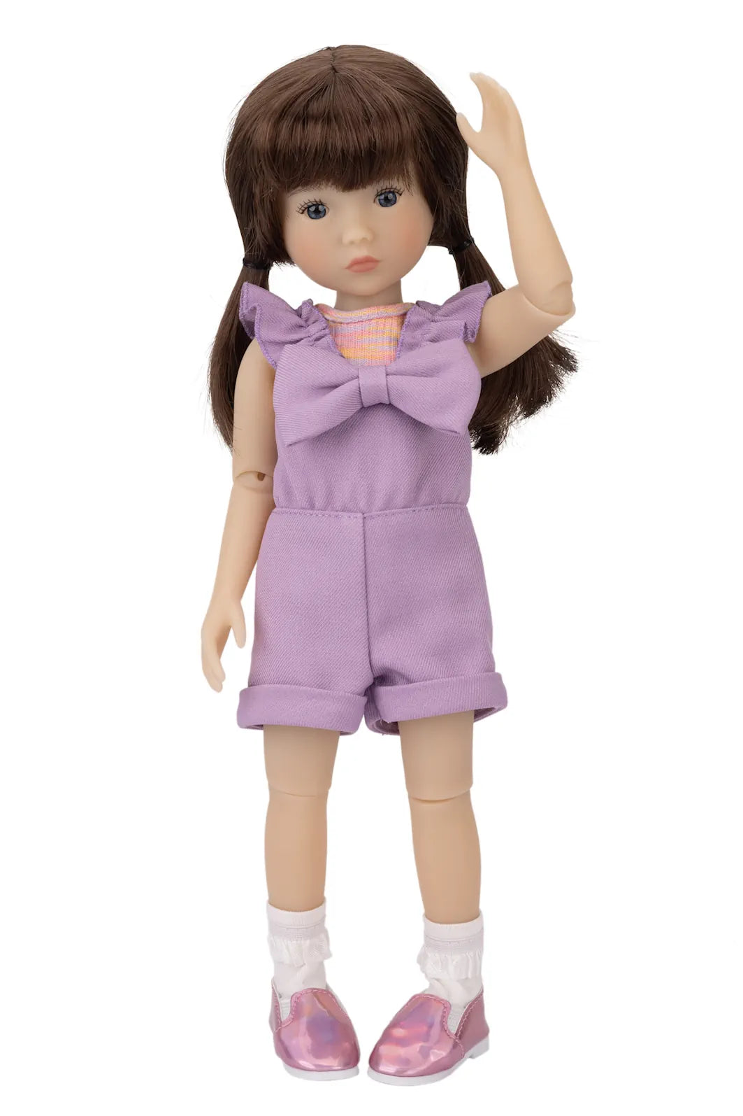 Doll wearing a purple outfit with a large bow on a white background