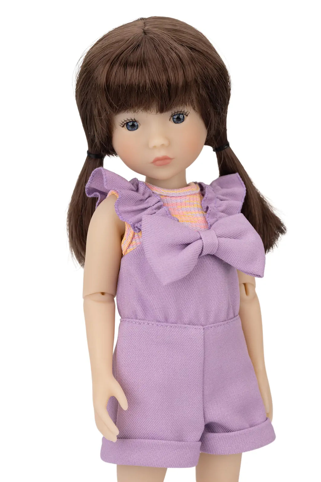Doll wearing a purple outfit with a large bow on a white background