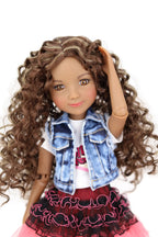 Doll with curly hair wearing a denim jacket and pink skirt on a white background