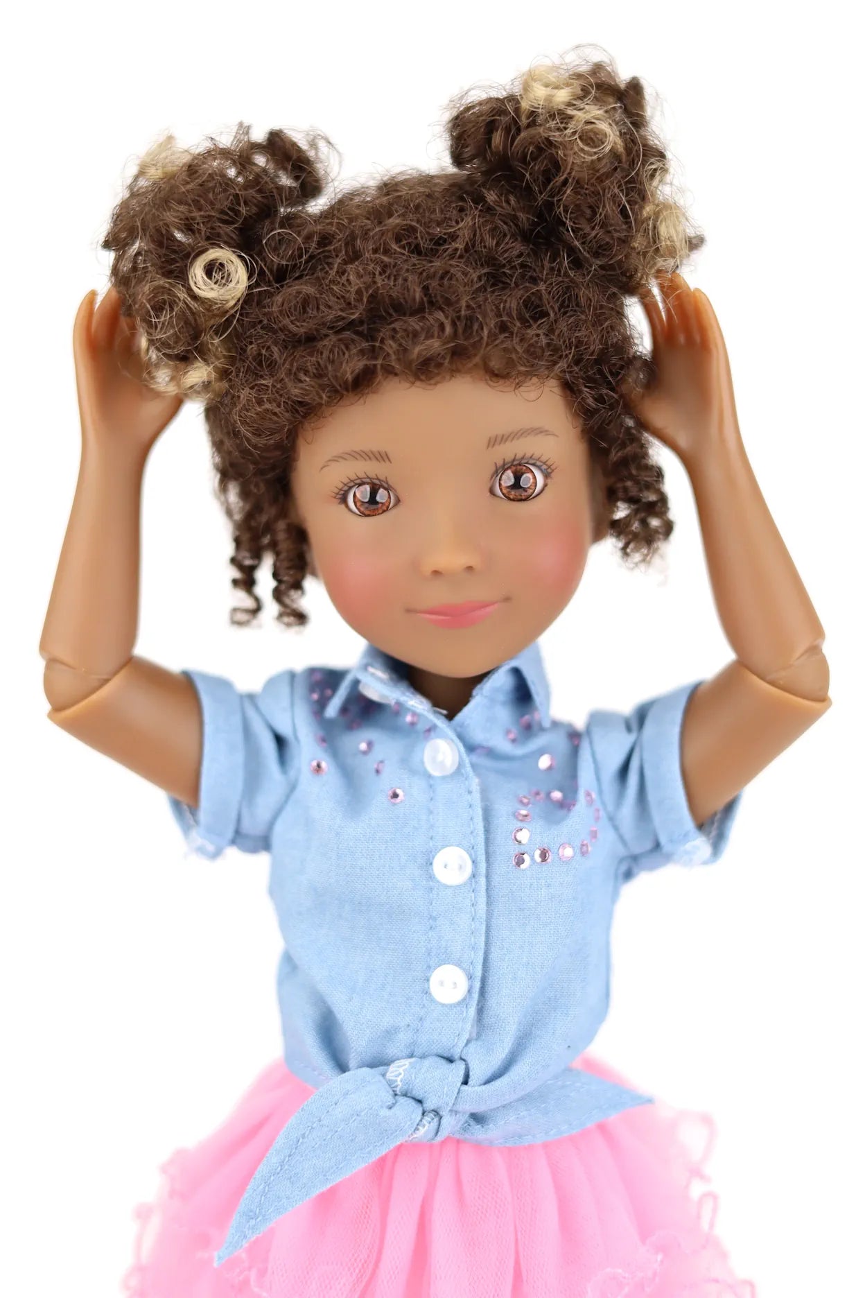 Doll with curly hair wearing a blue shirt and pink skirt on a white background