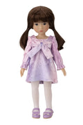 Doll wearing a purple dress with a bow on a white background