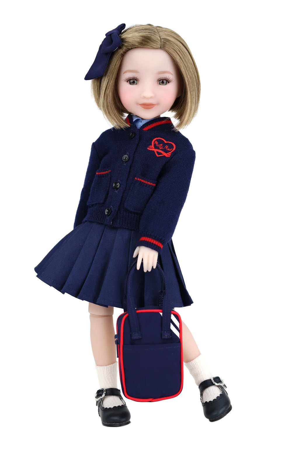 Doll wearing a navy blue school uniform with a red bag on a white background