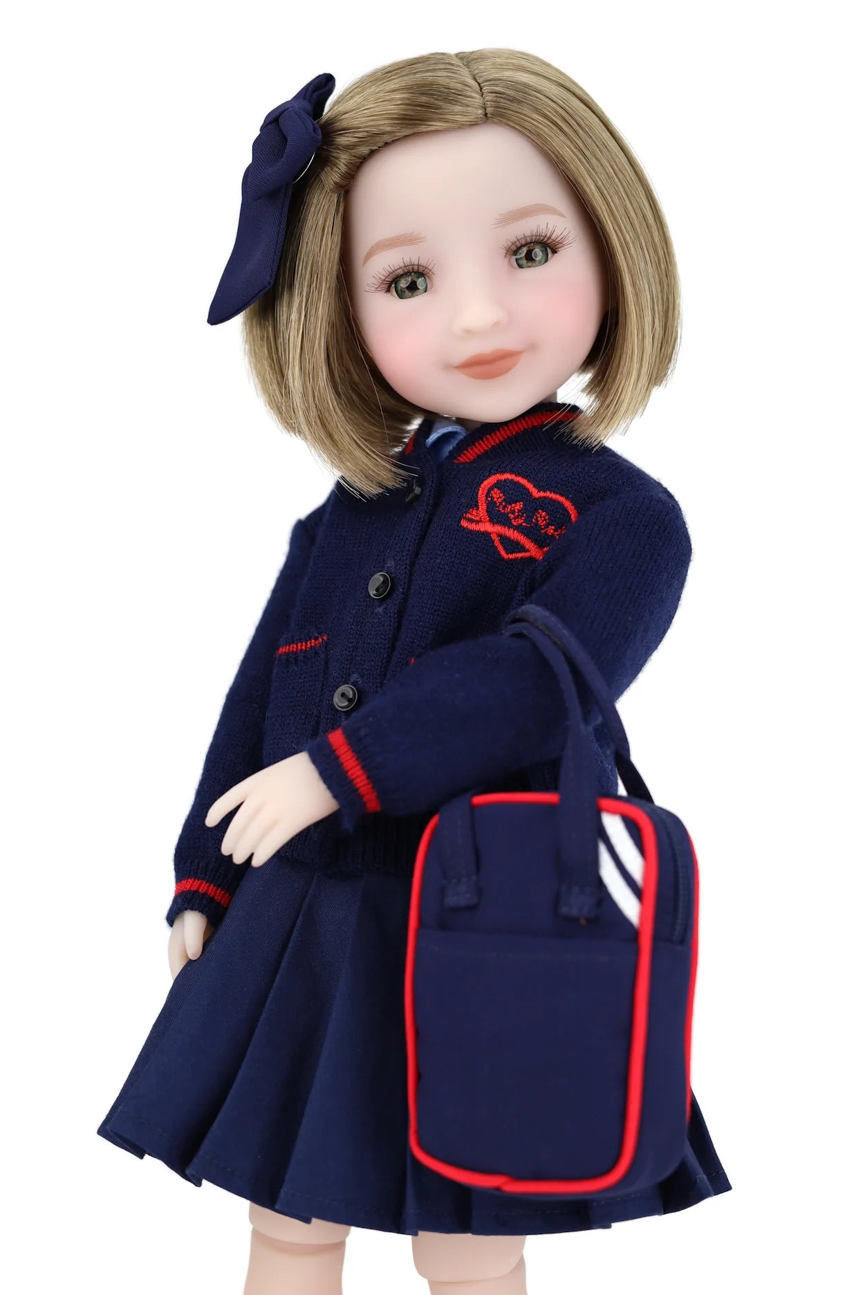 Doll wearing a navy blue school uniform with a red heart emblem on a white background