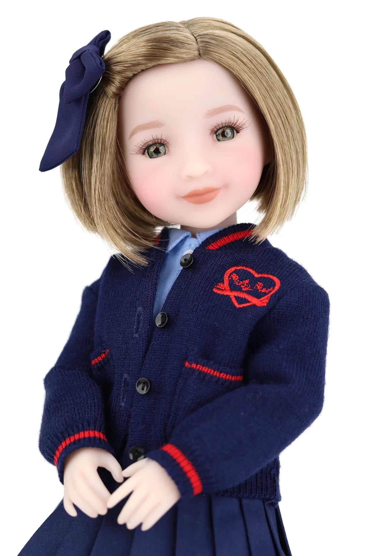 Doll wearing a navy blue cardigan with red accents on a white background