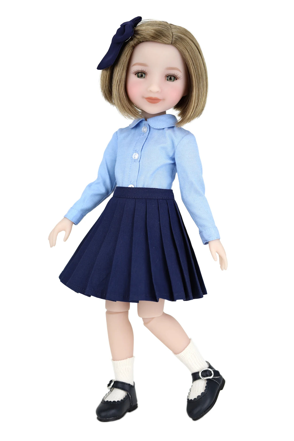 Doll wearing a blue shirt and navy pleated skirt with a white background