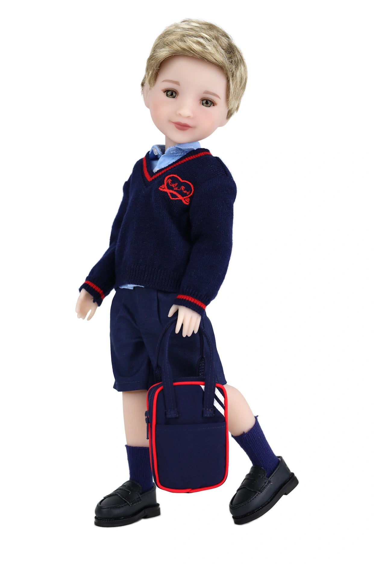 Doll wearing a navy blue school uniform with red emblem on a white background