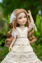 Doll with long brown hair and a white lace dress against a blurred green background