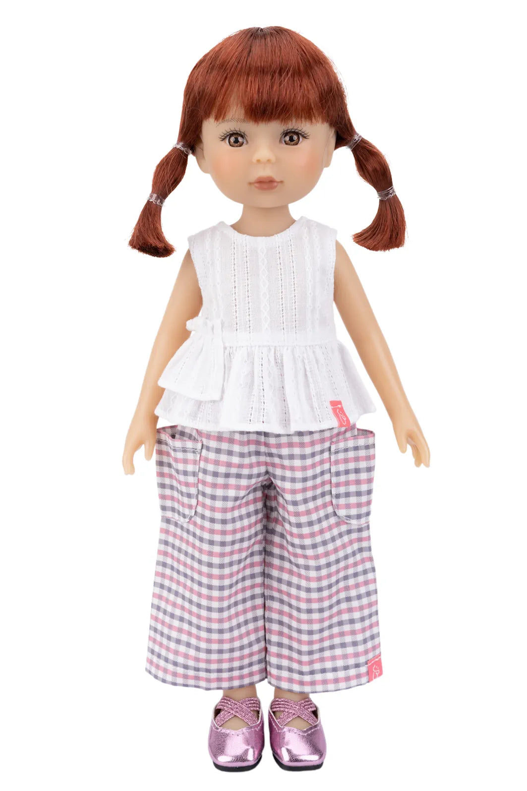 Doll with a white top and red, blue and white checkered pants on a white background