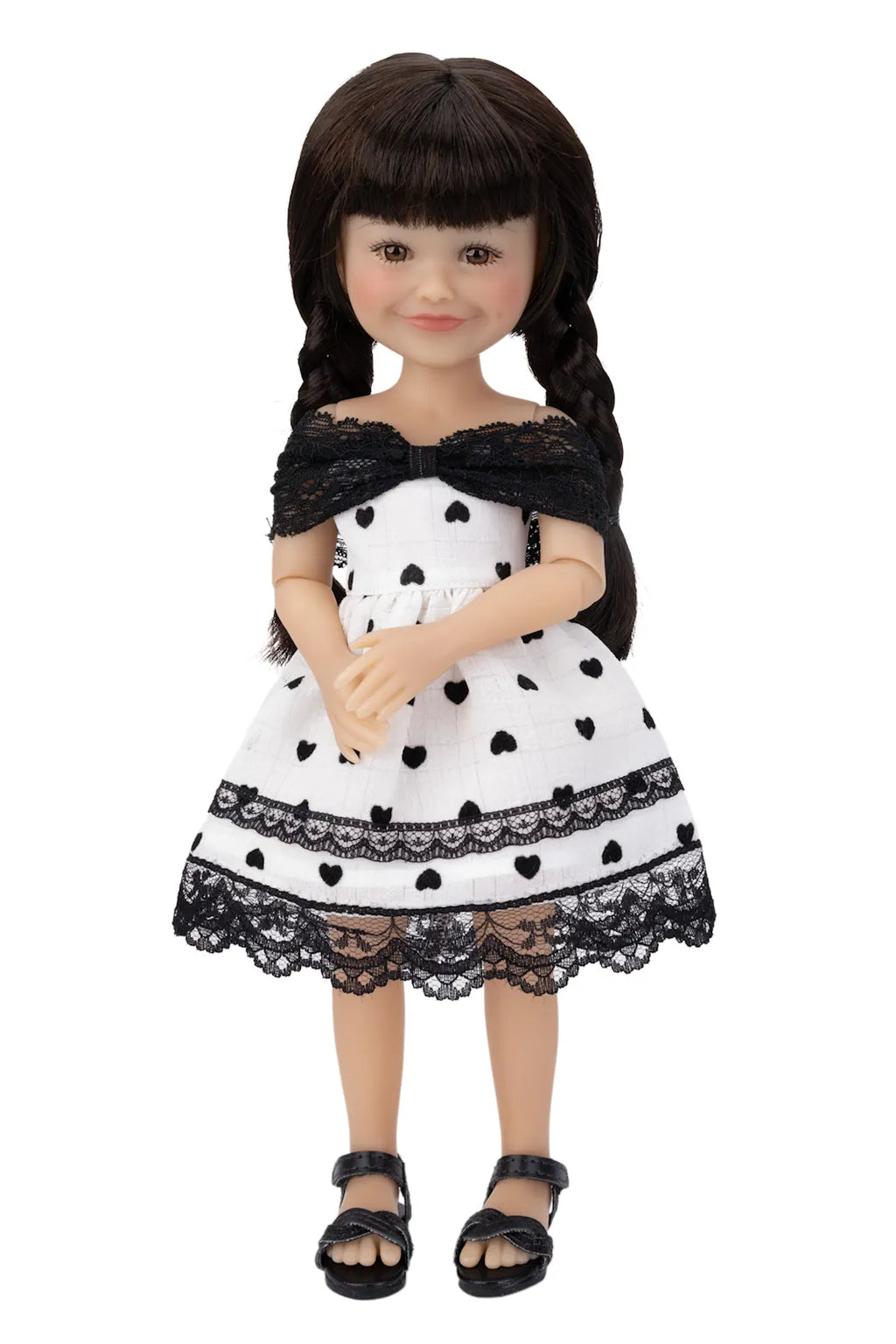 Doll wearing a black and white polka dot dress with lace details on a white background
