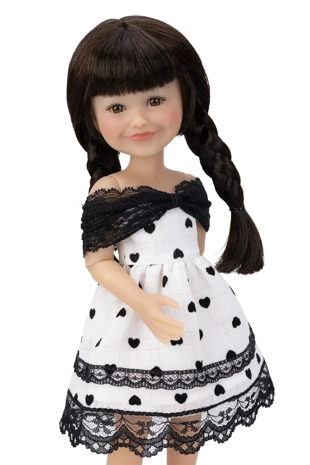 Doll wearing a white dress with black heart patterns and lace details on a white background