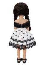 Doll wearing a black and white dress with heart patterns on a white background