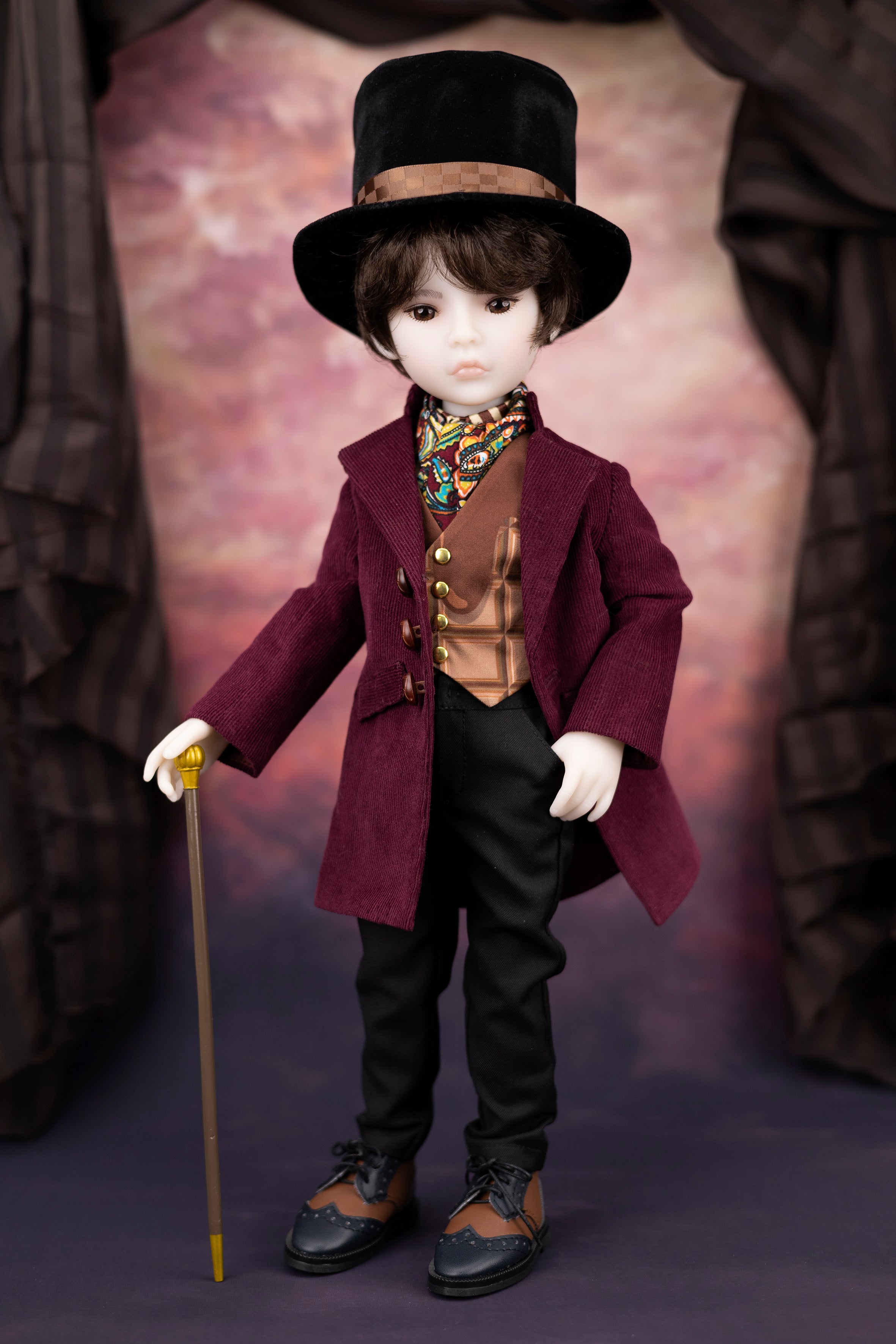 Doll in a Victorian-style outfit with a top hat and coat, holding a cane.