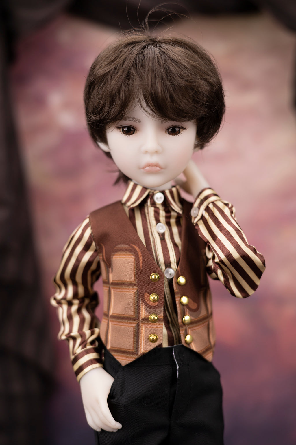 Doll wearing a brown and gold outfit with a textured background