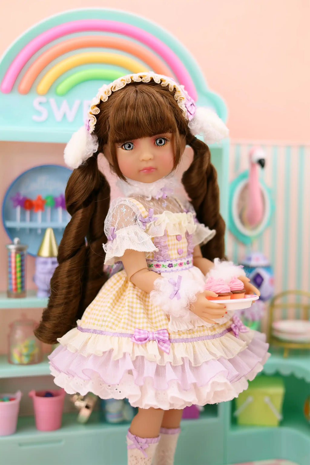 Doll in a pastel dress with a rainbow and candy-themed background