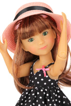Bailey wearing a pink hat and black polka dot dress on a white background