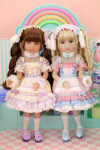 Two dolls in pastel outfits standing in front of a rainbow, with a pink checkered floor and light blue wall in the background.