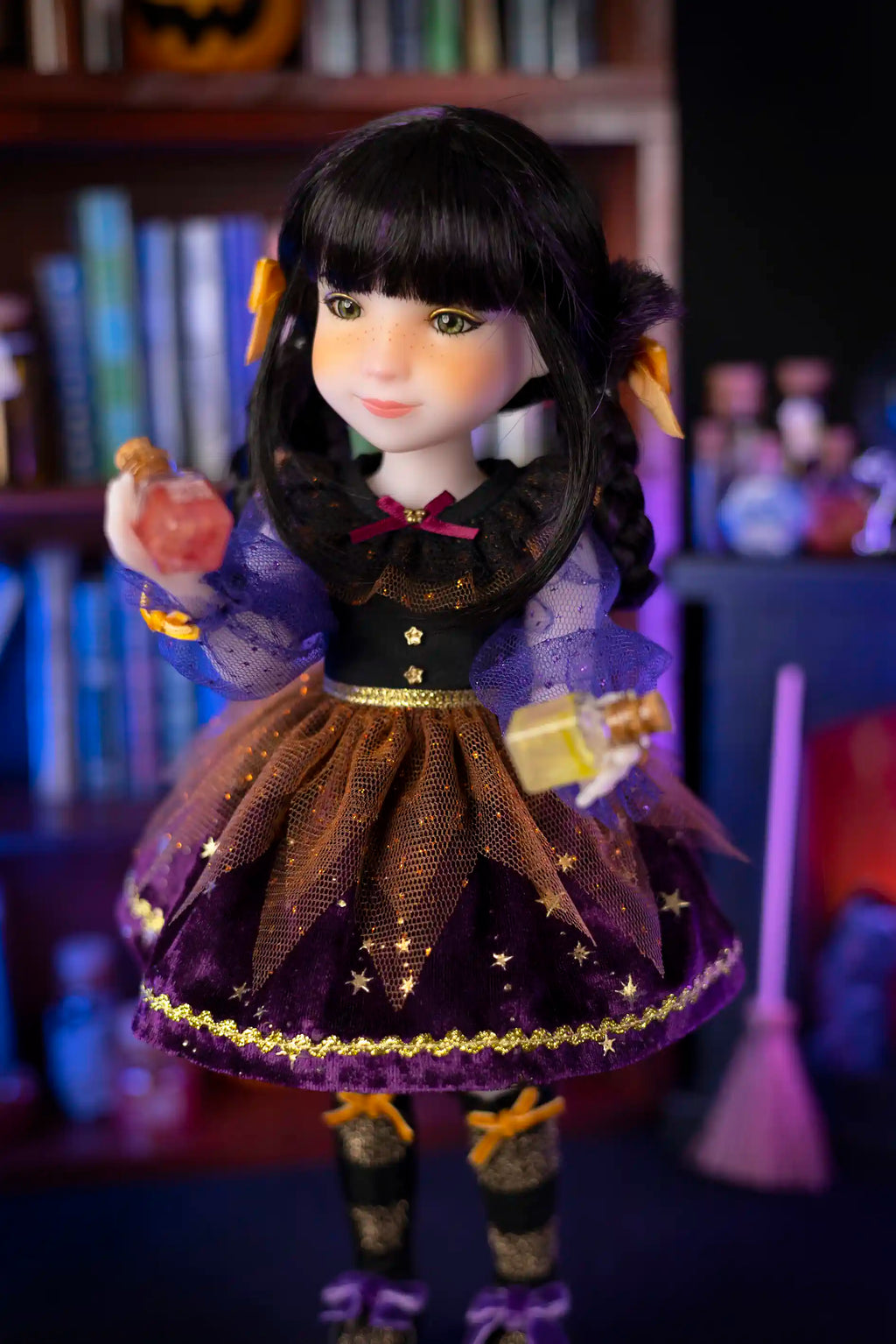 Doll with dark hair and purple outfit in a Halloween-themed setting