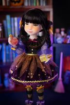 Doll with dark hair and purple outfit in a Halloween-themed setting